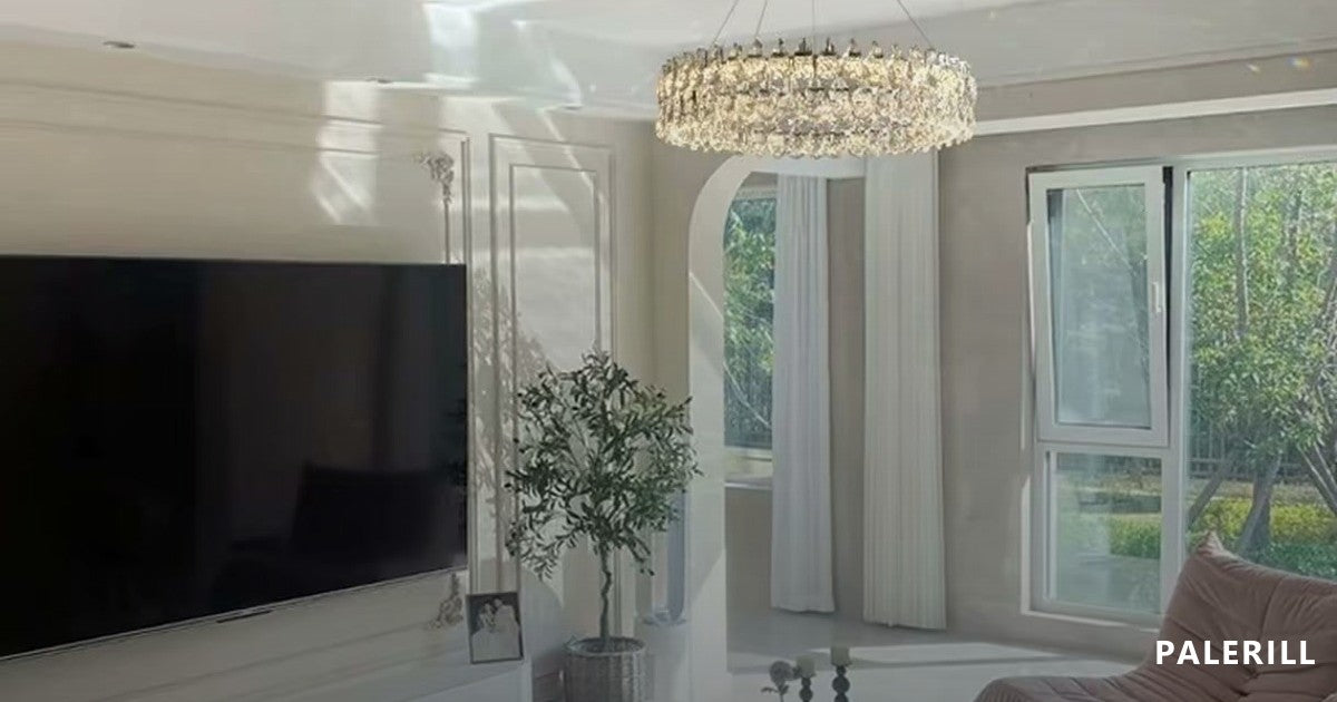 Round multi-tier crystal chandelier in a large modern living room, photographed with the surrounding furniture so the scale reads