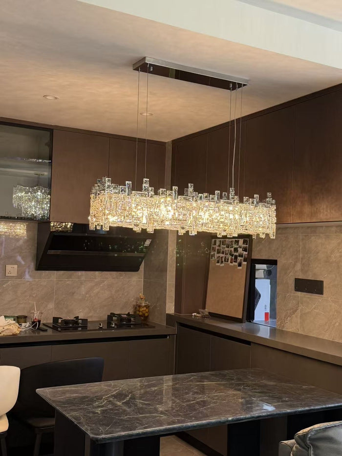 Linear crystal island chandelier over a dark kitchen island