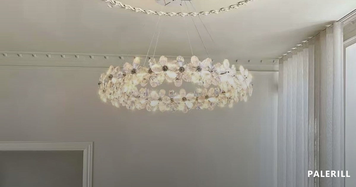 Crystal chandelier with flower-cut glass petals photographed lit, the individual lamps visible inside the petals, in a pale interior with a coffered ceiling