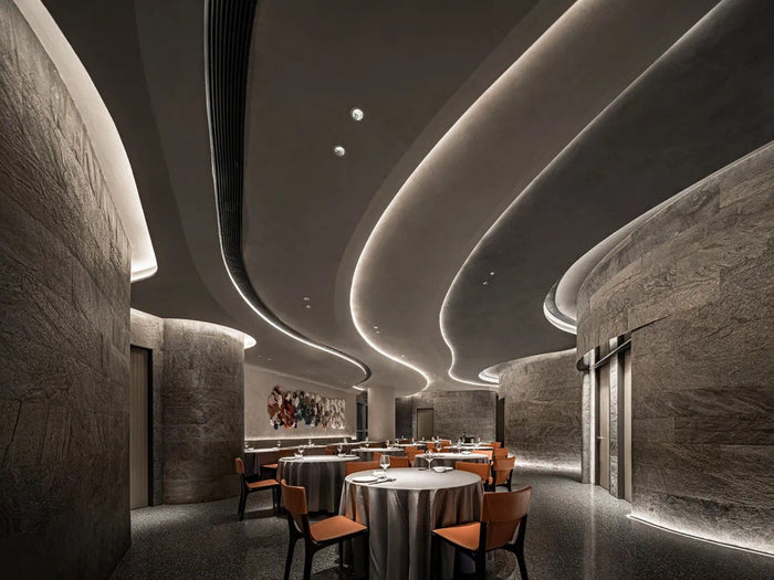 Fine-dining room with sculpted linear ceiling lighting