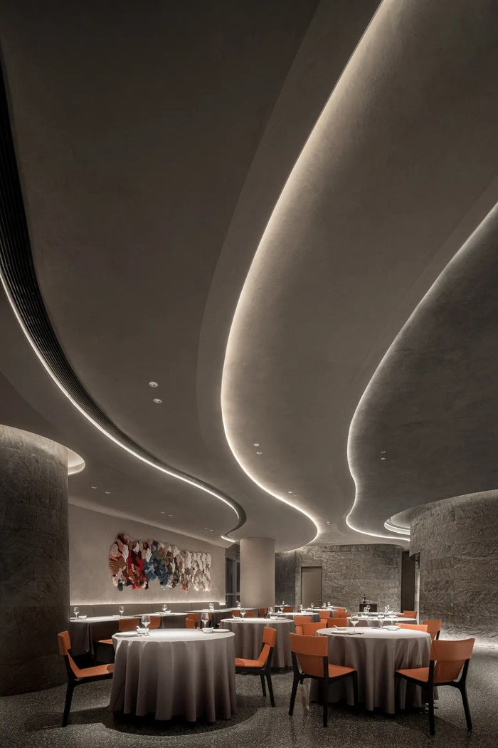 Fine-dining room with sculpted linear ceiling lighting