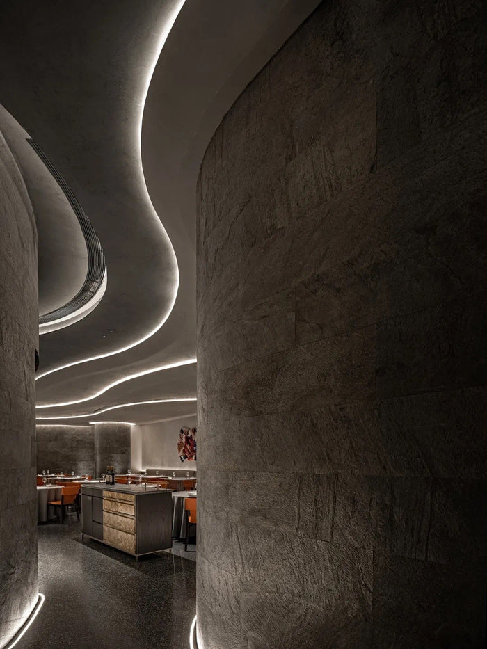 Fine-dining room with sculpted linear ceiling lighting