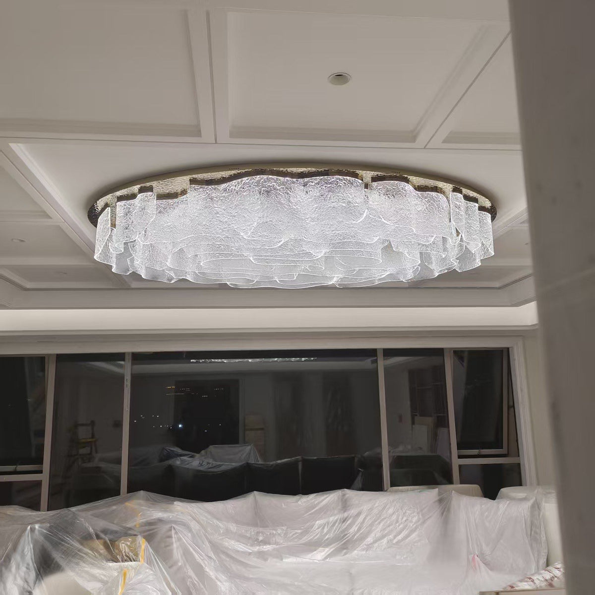 Flush ovoid crystal ceiling chandelier installed in a coffered ceiling