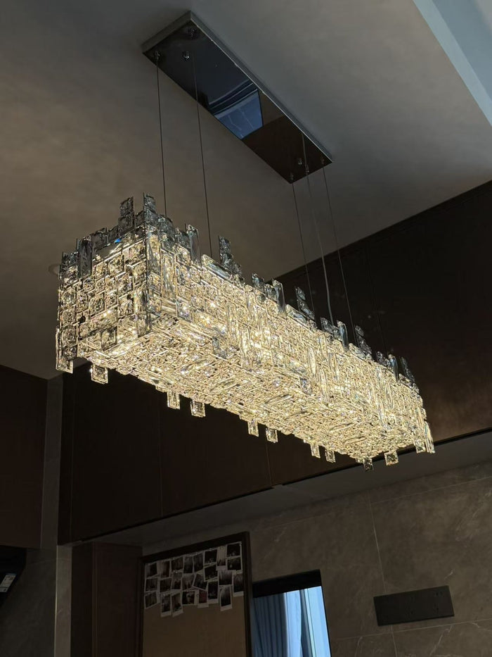 Linear crystal island chandelier over a dark kitchen island