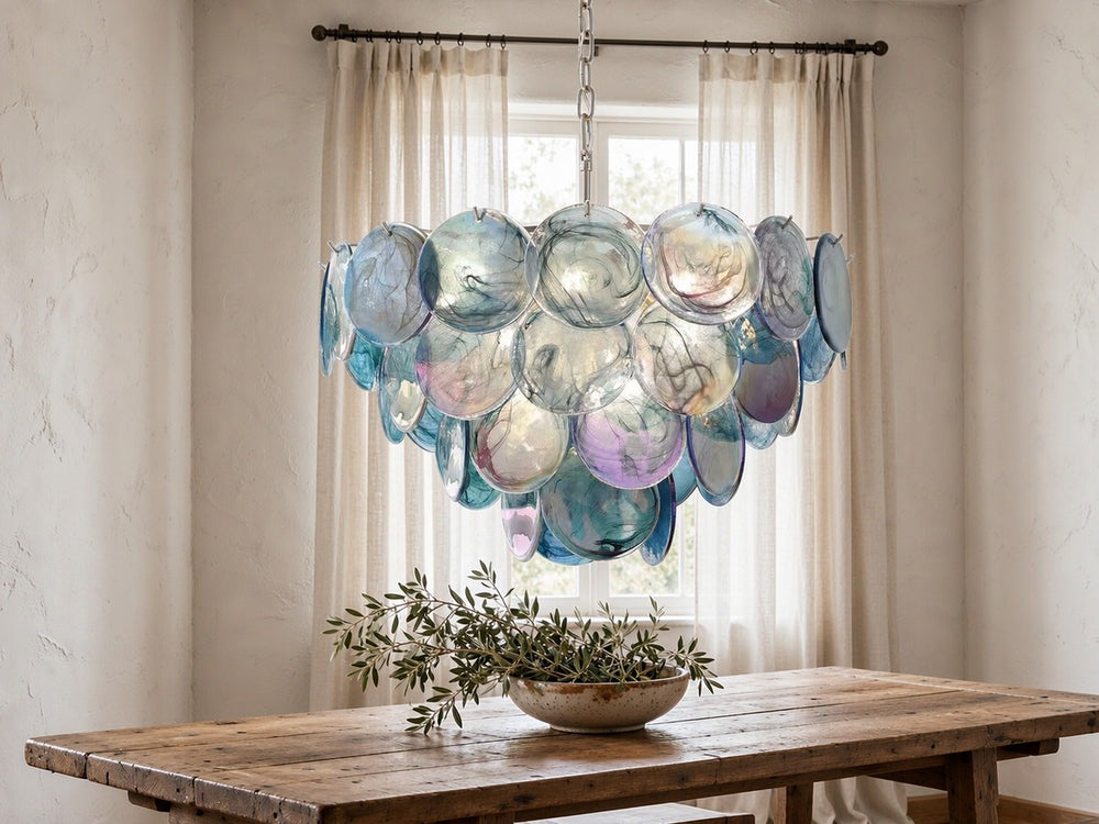 Hand-blown Murano glass disc chandelier in aqua and violet tones above a rustic oak dining table
