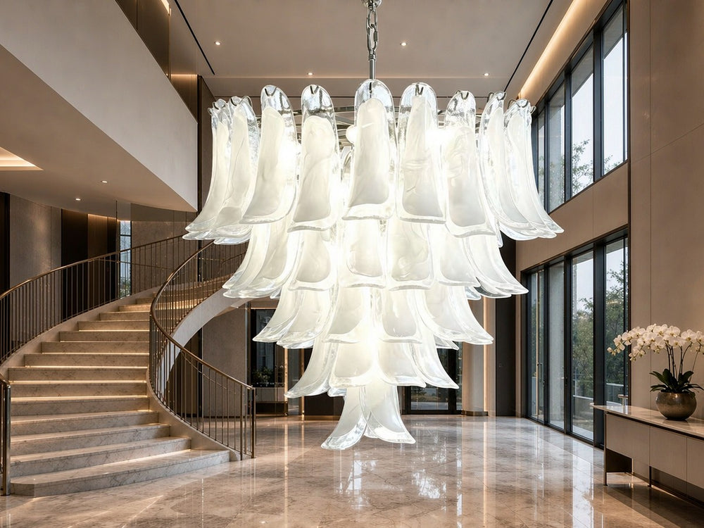 Tiered frosted glass petal chandelier in a double-height marble entrance hall with a curving staircase